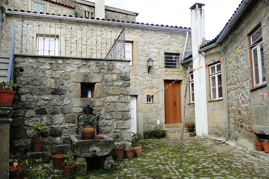 Stone village house with pots of flowers by the door